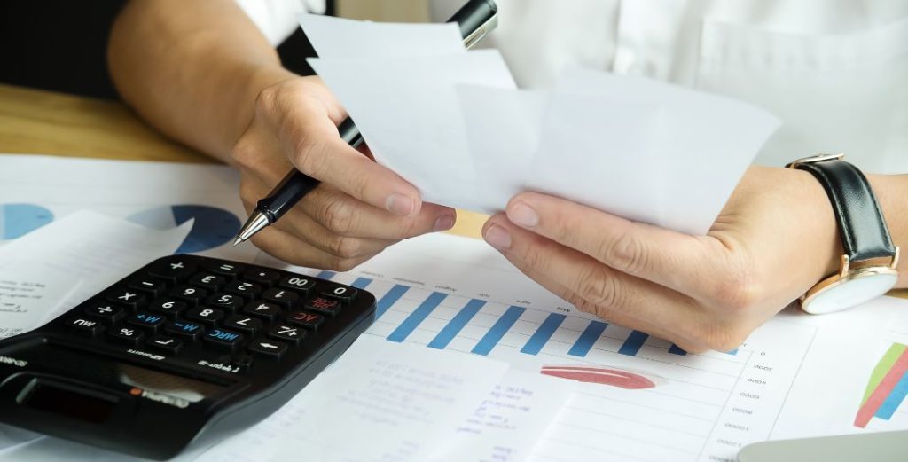 person comparing options with calculator and graphs